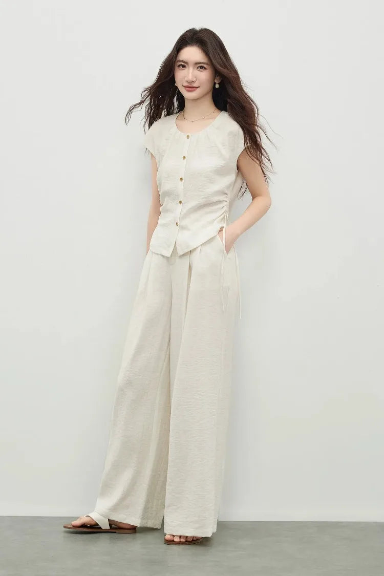 An elegant pose of a woman with one hand in her trouser pocket, emphasizing the effortless flow of the wide-leg cut. — From Borcelleclothes.