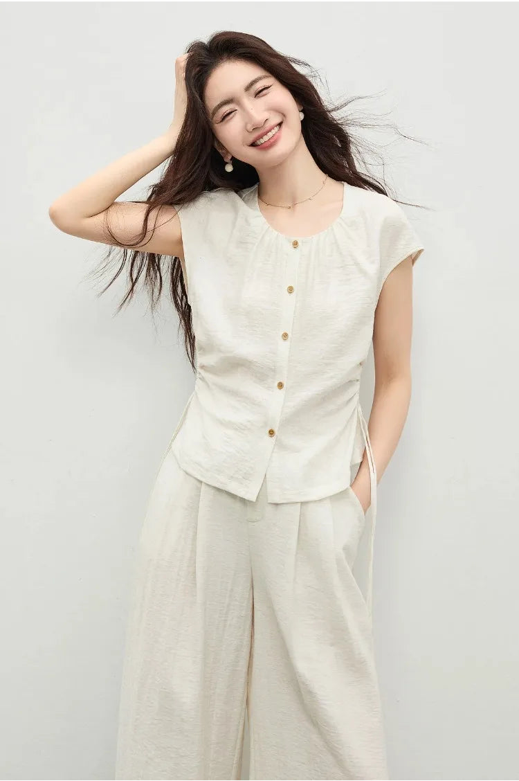 An elegant pose of a woman with one hand in her trouser pocket, emphasizing the effortless flow of the wide-leg cut. — From Borcelleclothes.