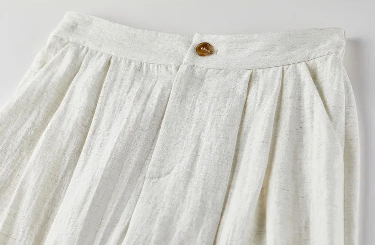 Focus on the front pleats and the smooth waistband of the wide-leg trousers. — From Borcelleclothes.