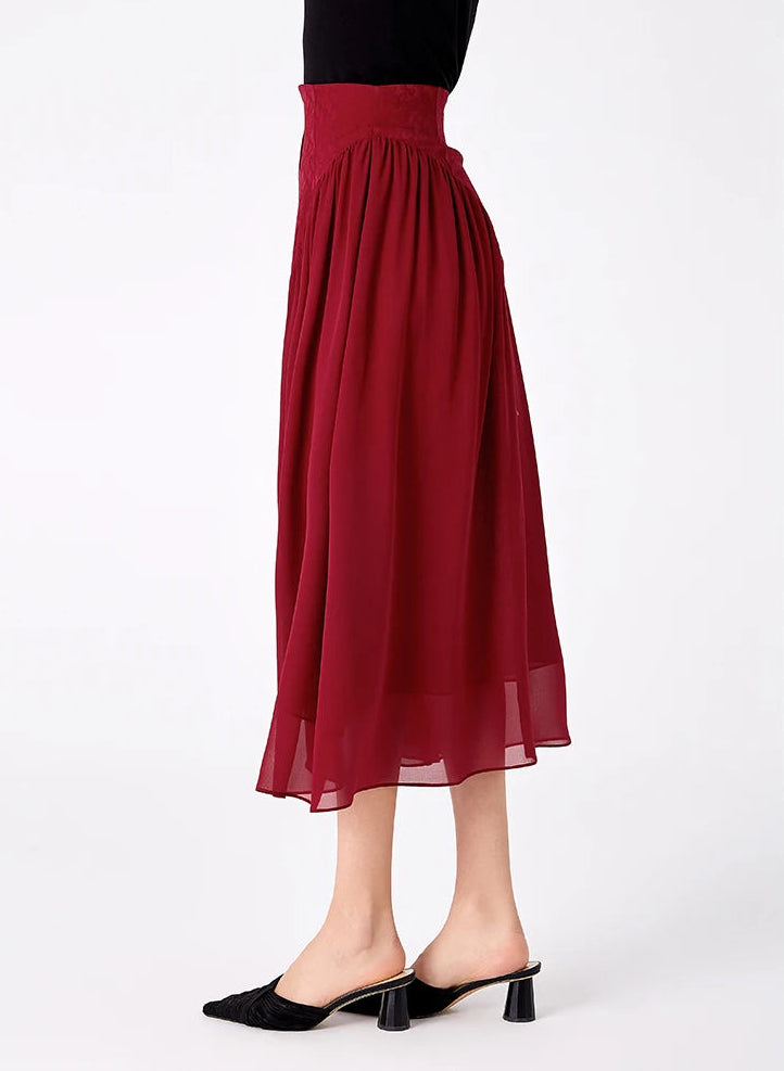Profile side view of a model wearing a high-waisted silk skirt with fluid georgette draping — From Borcelleclothes.