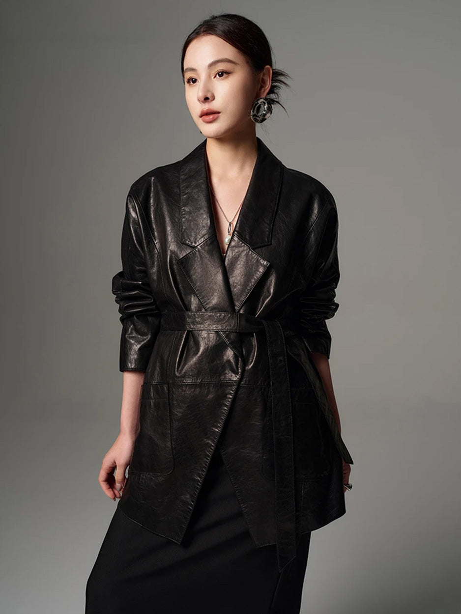 Model with head turned in profile wearing the cinched glazed goatskin wrap jacket with dropped lapels — From Borcelleclothes.