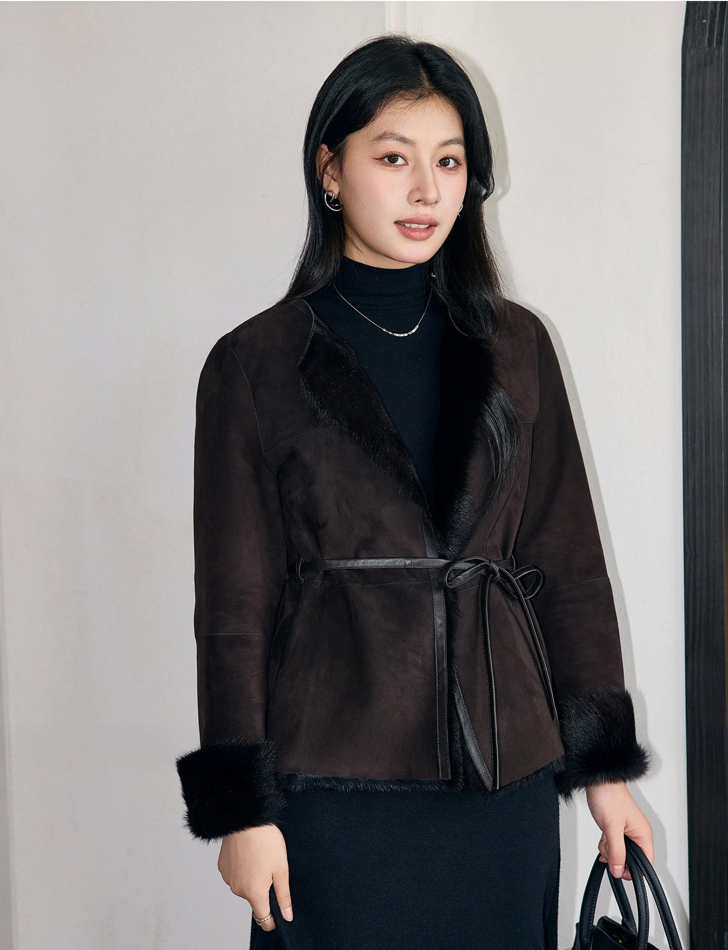 Front-facing view of the Tamarind goatskin jacket, showing round neckline, leather belt, and matte suede finish — From Borcelleclothes.