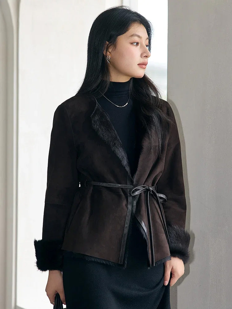 Model looking out the window in the Tamarind goatskin jacket with visible round neckline and subtle fur lining — From Borcelleclothes.