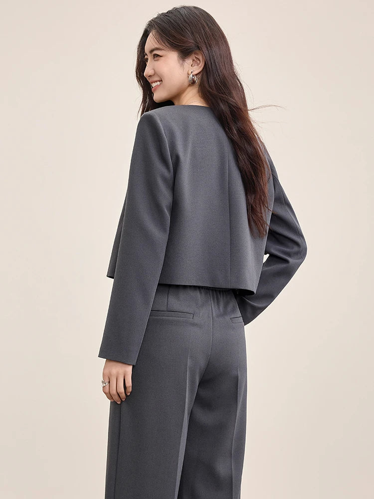 Back view of a woman wearing the Gris Phénix cropped jacket, showing the precise structural drape — From Borcelleclothes.