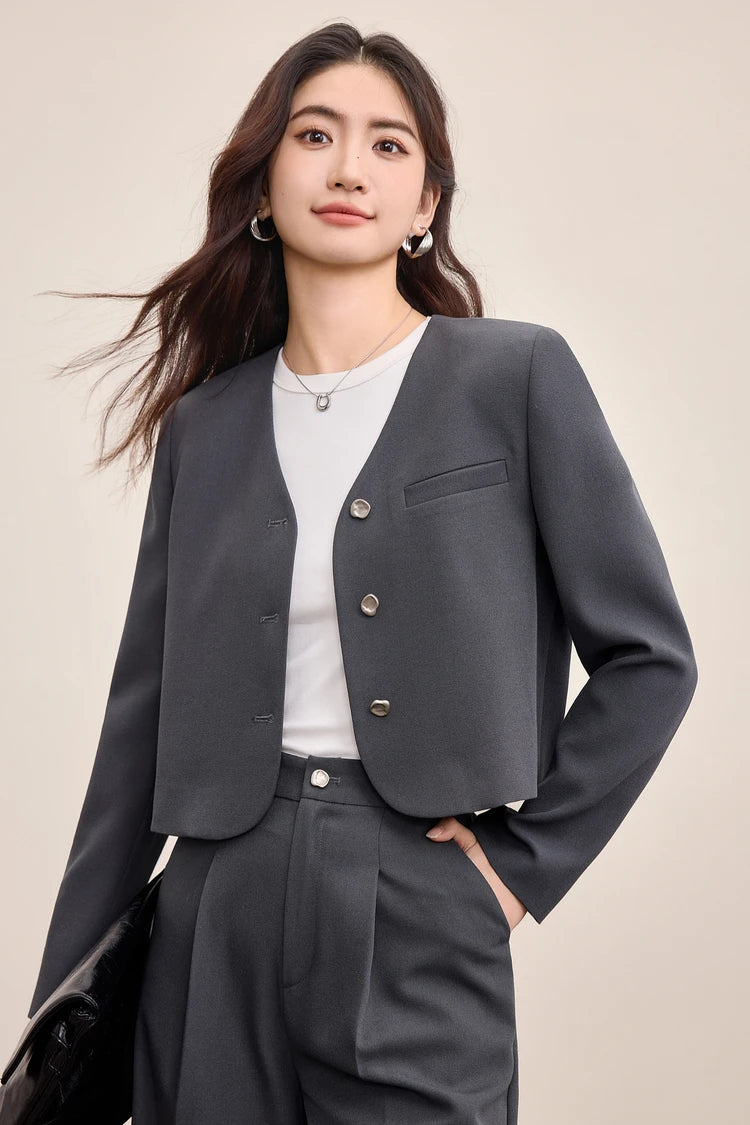 A confident woman holding a bag with one hand in her pocket, showcasing the functionality of the Gris Phénix trousers — From Borcelleclothes.