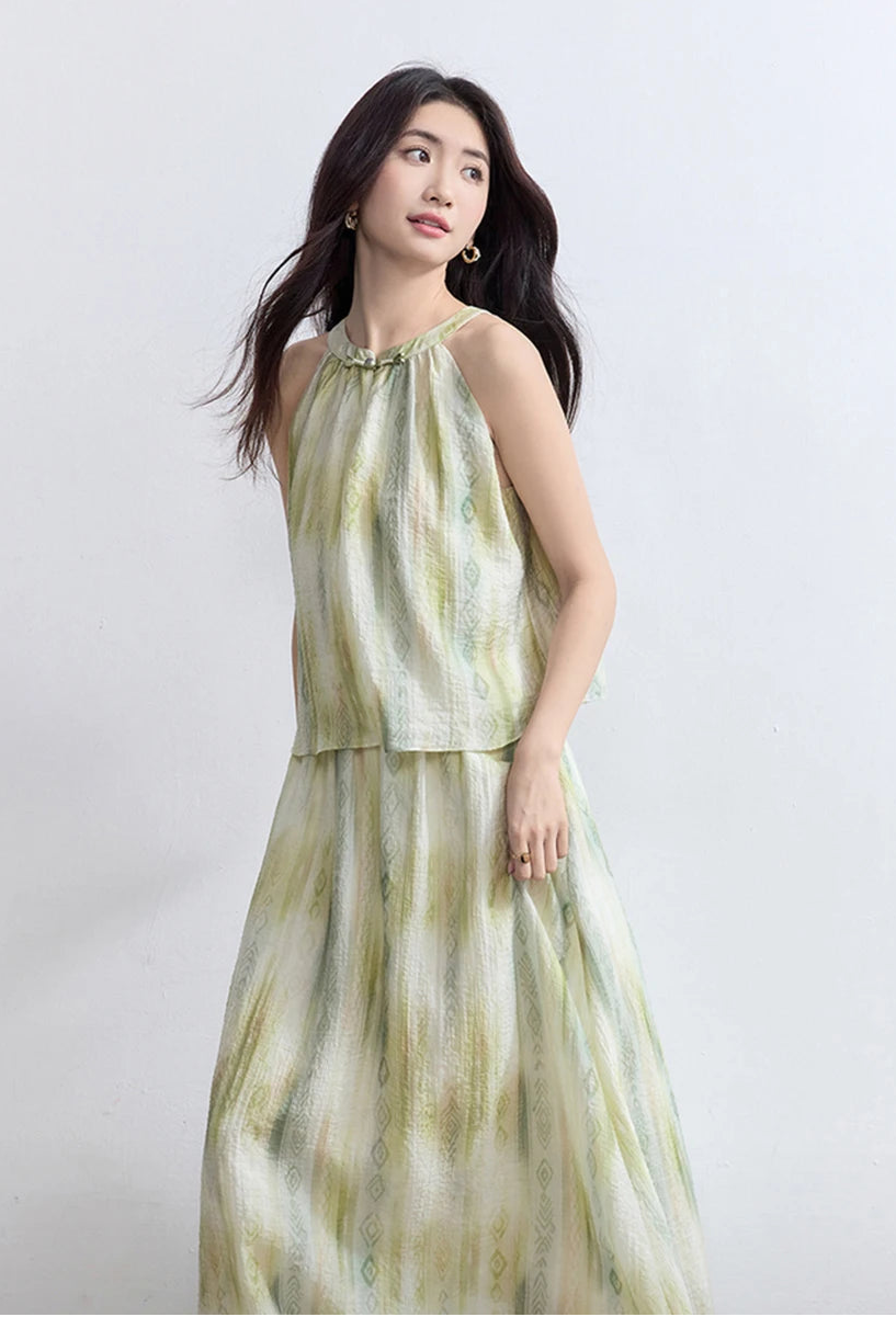 Side view of a woman walking, capturing the dynamic movement of the flared midi skirt and halter top — From Borcelleclothes.
