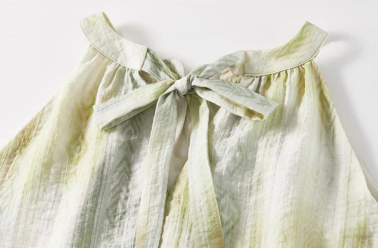Close-up of the long ribbons tied into a soft bow at the nape of the neck, veilng the back cut-out — From Borcelleclothes.
