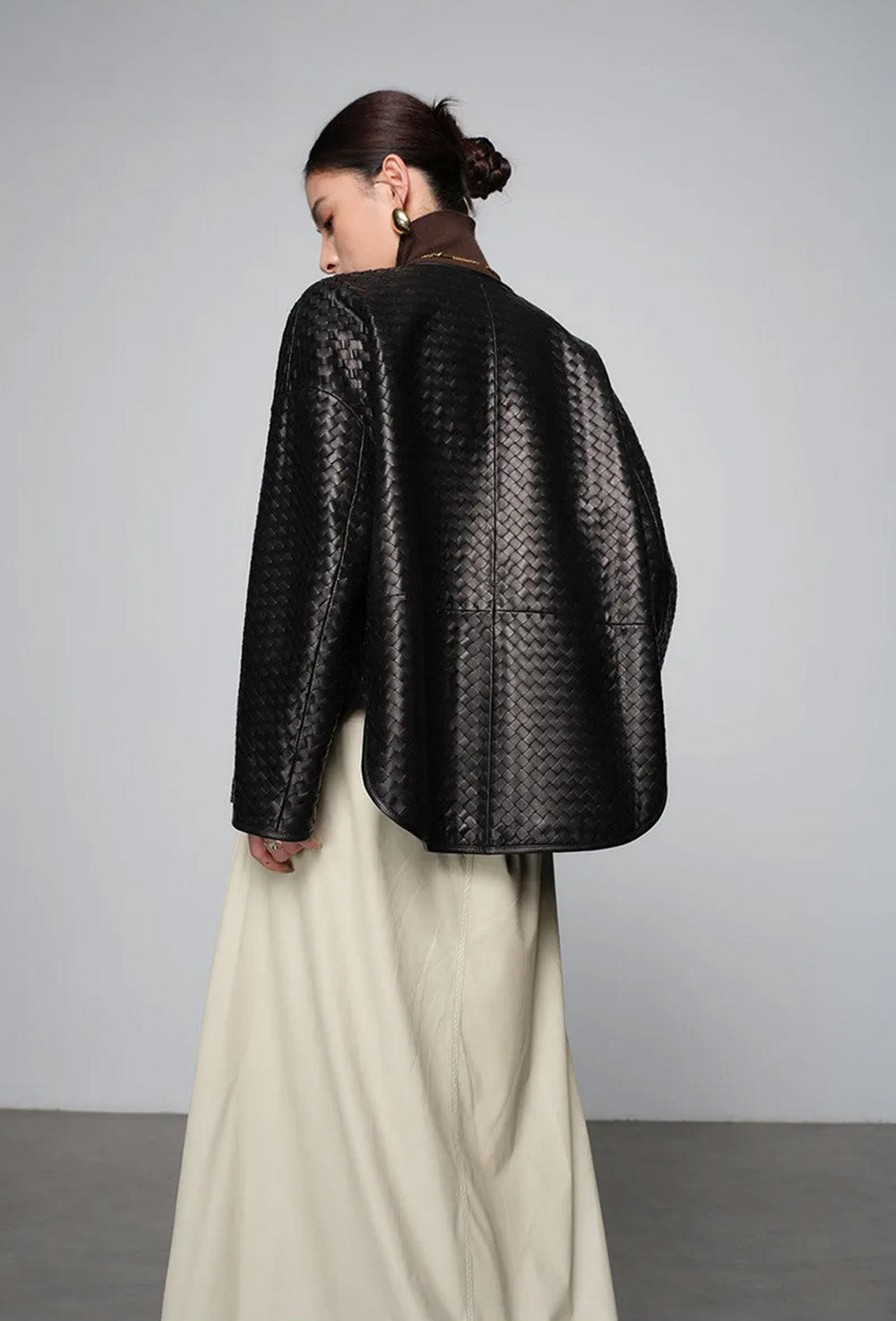 Back view of hand-woven sheepskin jacket showing seamless pattern alignment and sloped shoulders — From Borcelleclothes.