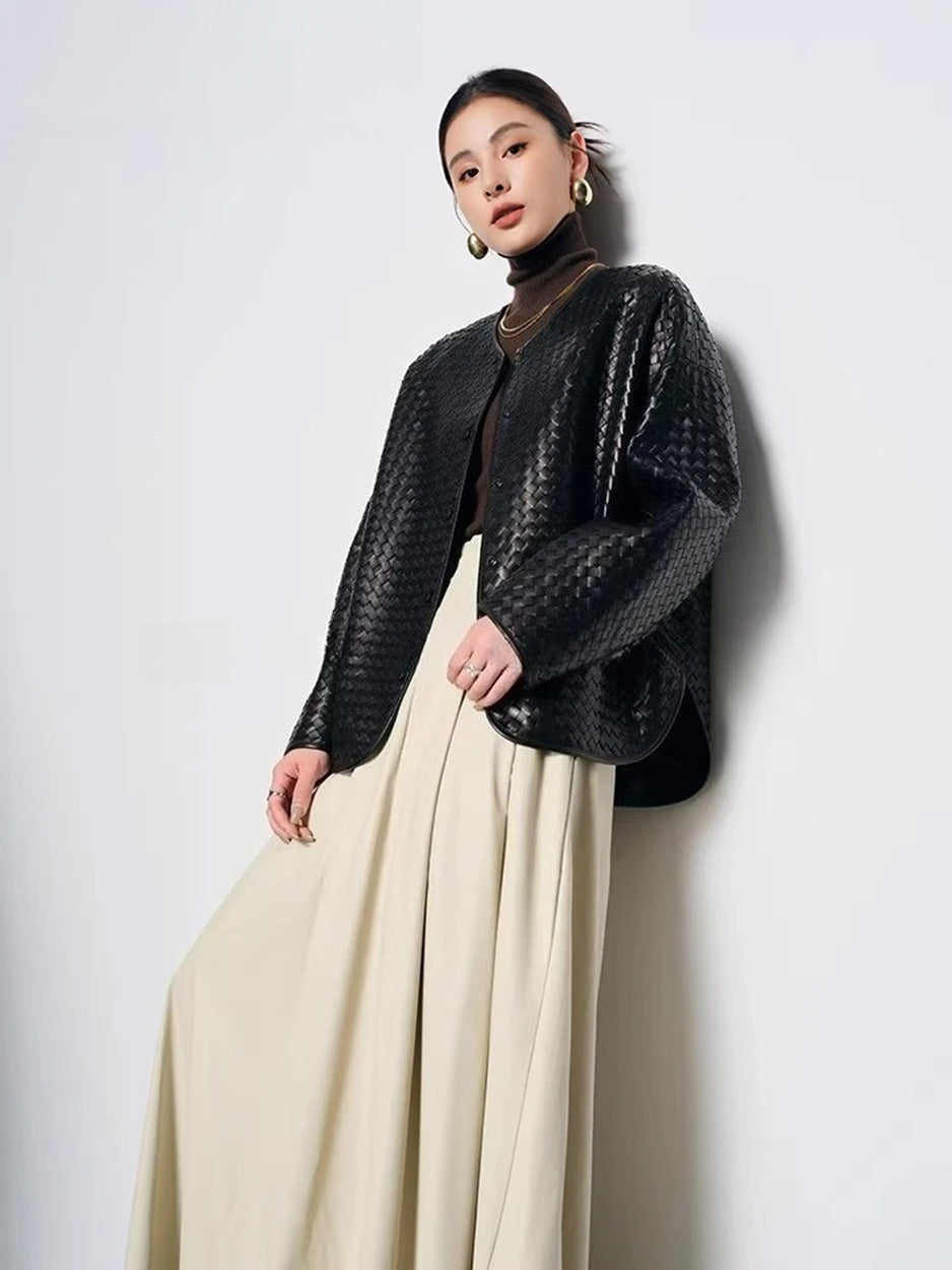 Full-height view of model in woven sheepskin cocoon jacket leaning against wall — From Borcelleclothes.