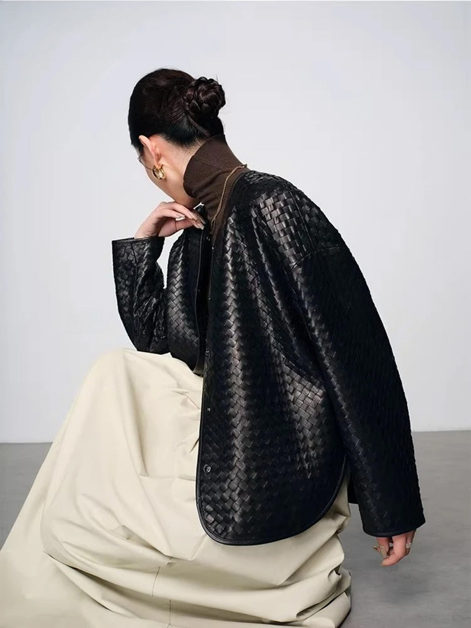 Model seated on floor showcasing sculptural drape of woven sheepskin nappa jacket — From Borcelleclothes.