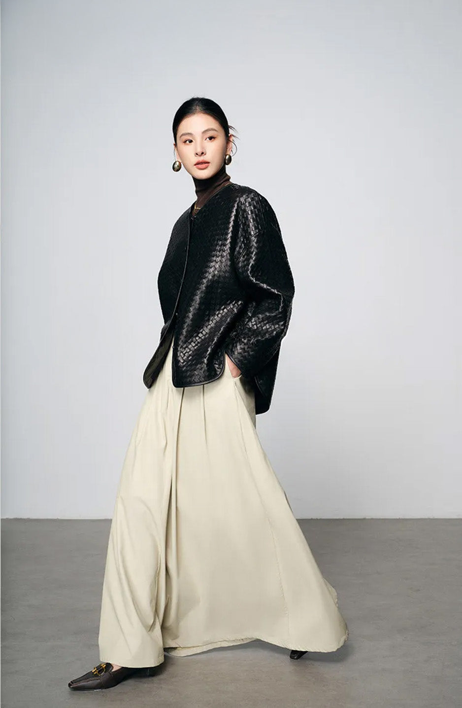 Dynamic side stride showcasing fluid motion and mercury sheen of woven sheepskin jacket — From Borcelleclothes.
