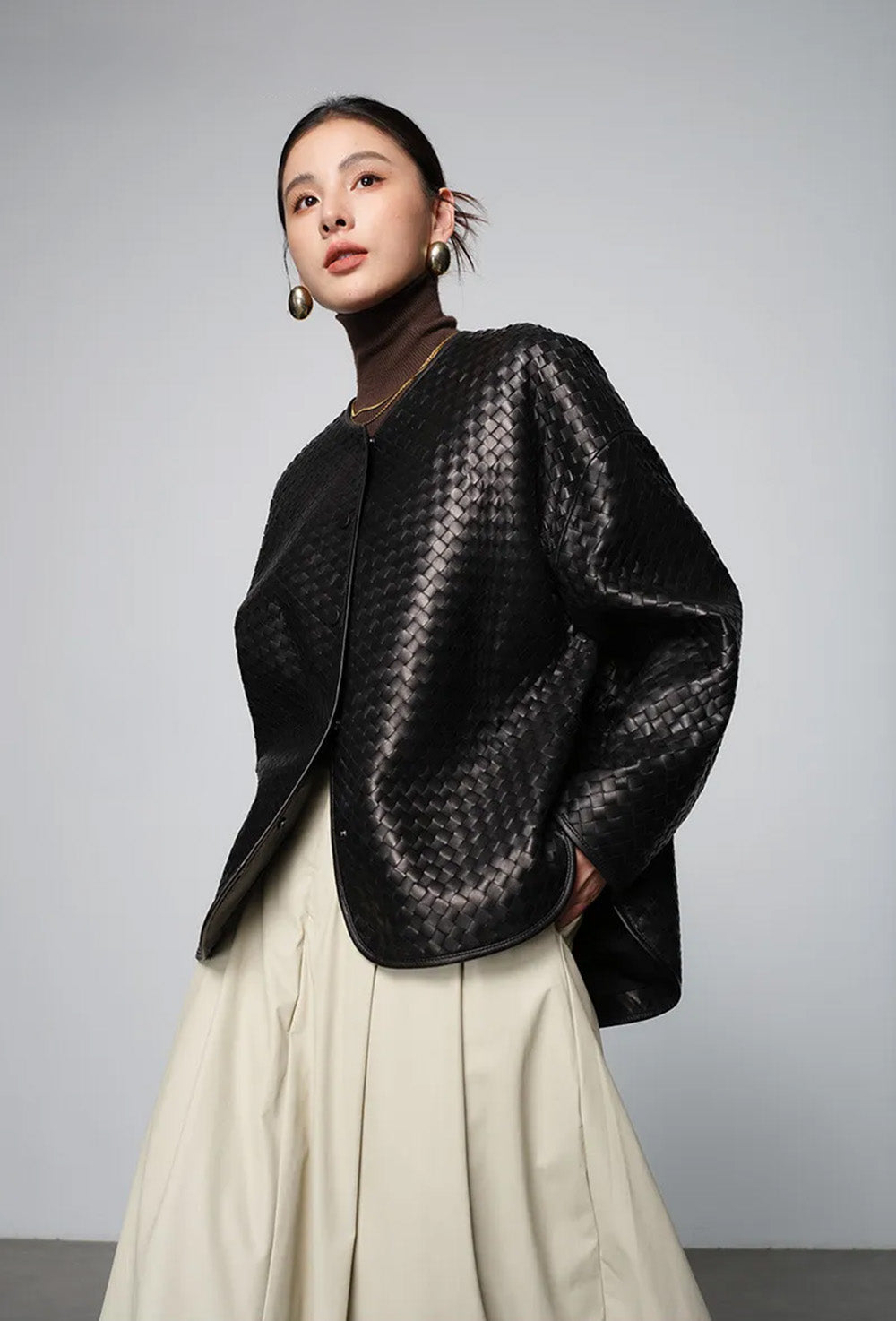 Women's Sculptural hand-woven sheepskin nappa jacket in Quicksilver Noir. Featuring diagonal geometric weaving, relaxed silhouette, and curved leather-bound edges. — From Borcelleclothes.