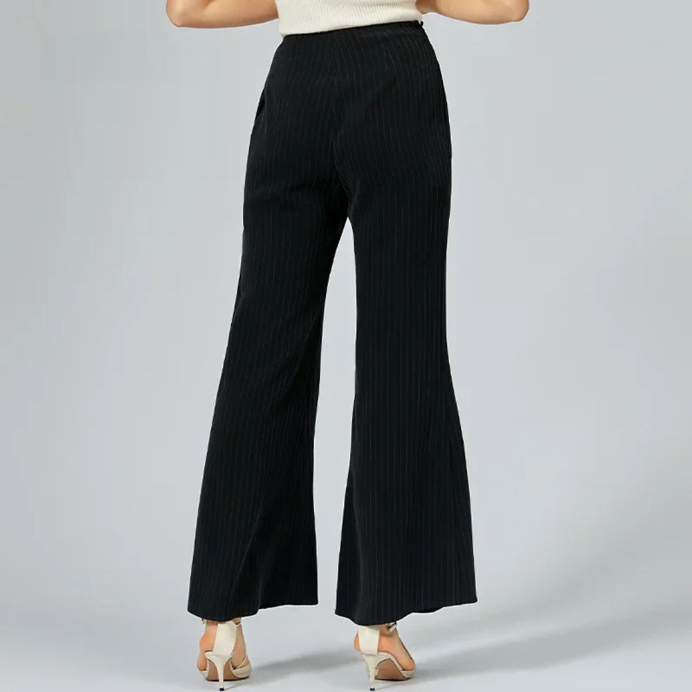 Back view of a model in pinstripe silk trousers posing with feet set apart — From Borcelleclothes.