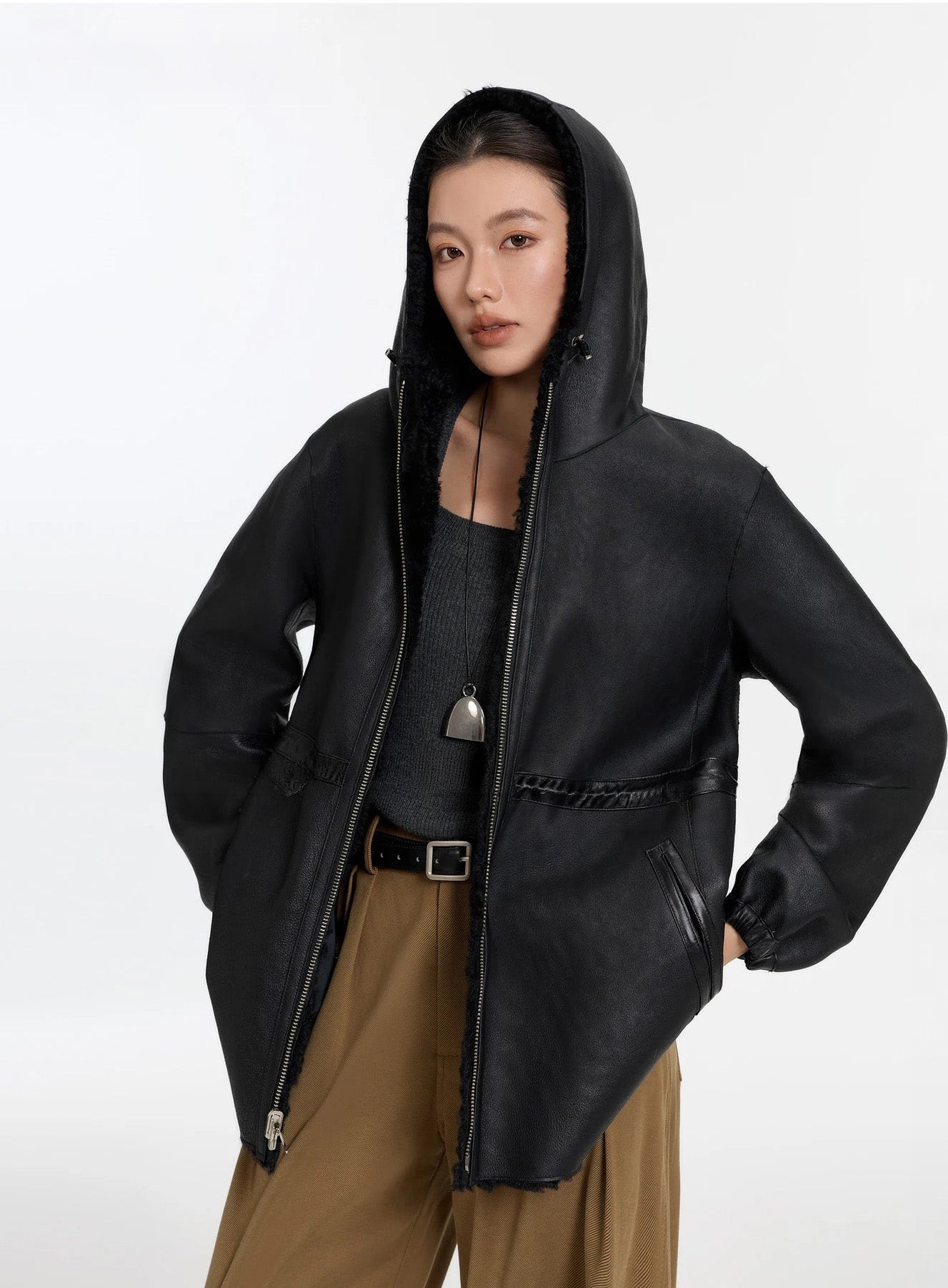 Model with hood up, wearing the Night Swirling coat, leather side — From Borcelleclothes.
