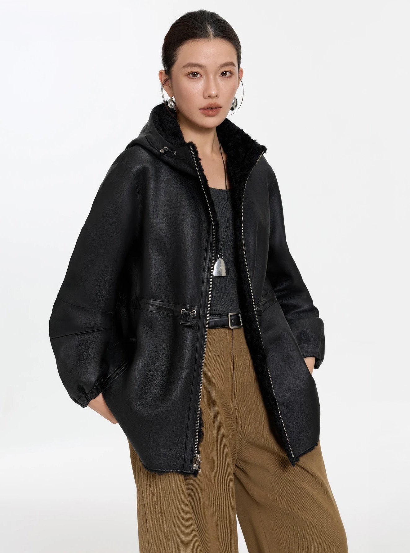 Model lifting the hem with both hands, Night Swirling coat, leather side — From Borcelleclothes.