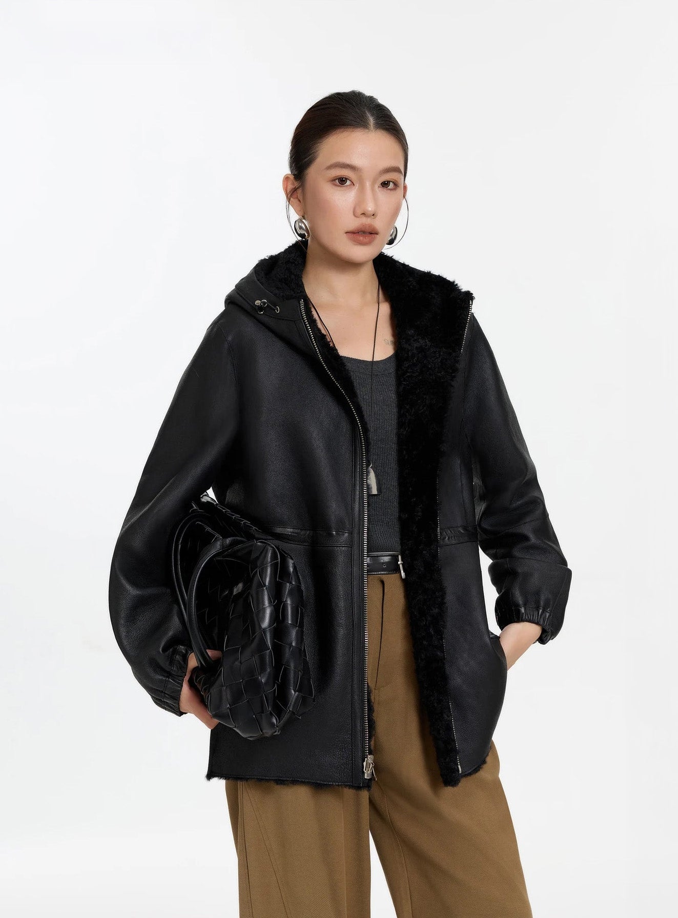 Model lifting the hem slightly, Night Swirling coat, leather side — From Borcelleclothes.
