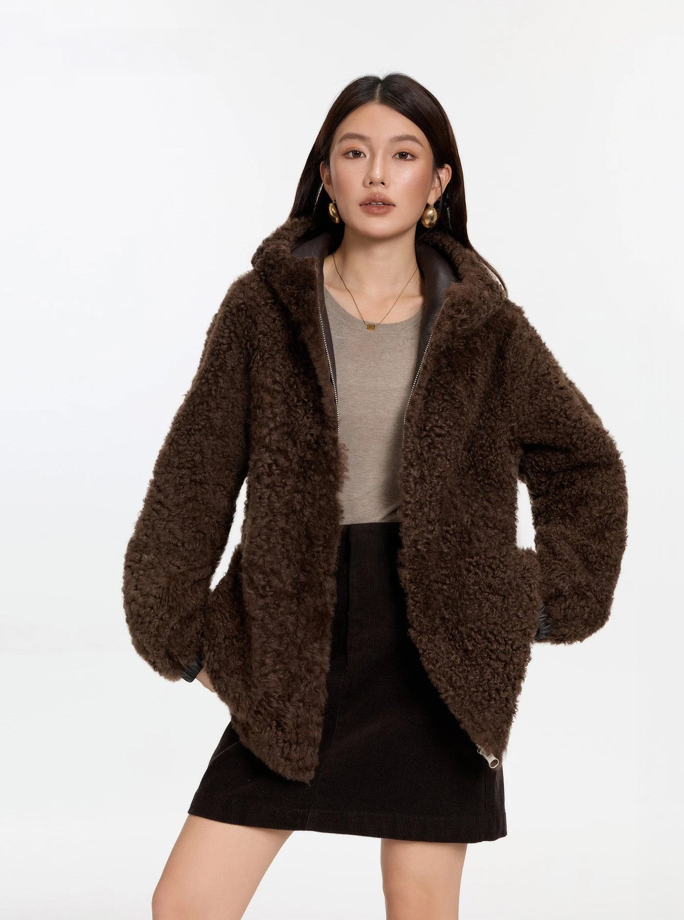 Model lifting the hem with both hands, Toffee Bloom coat, fur side — From Borcelleclothes.