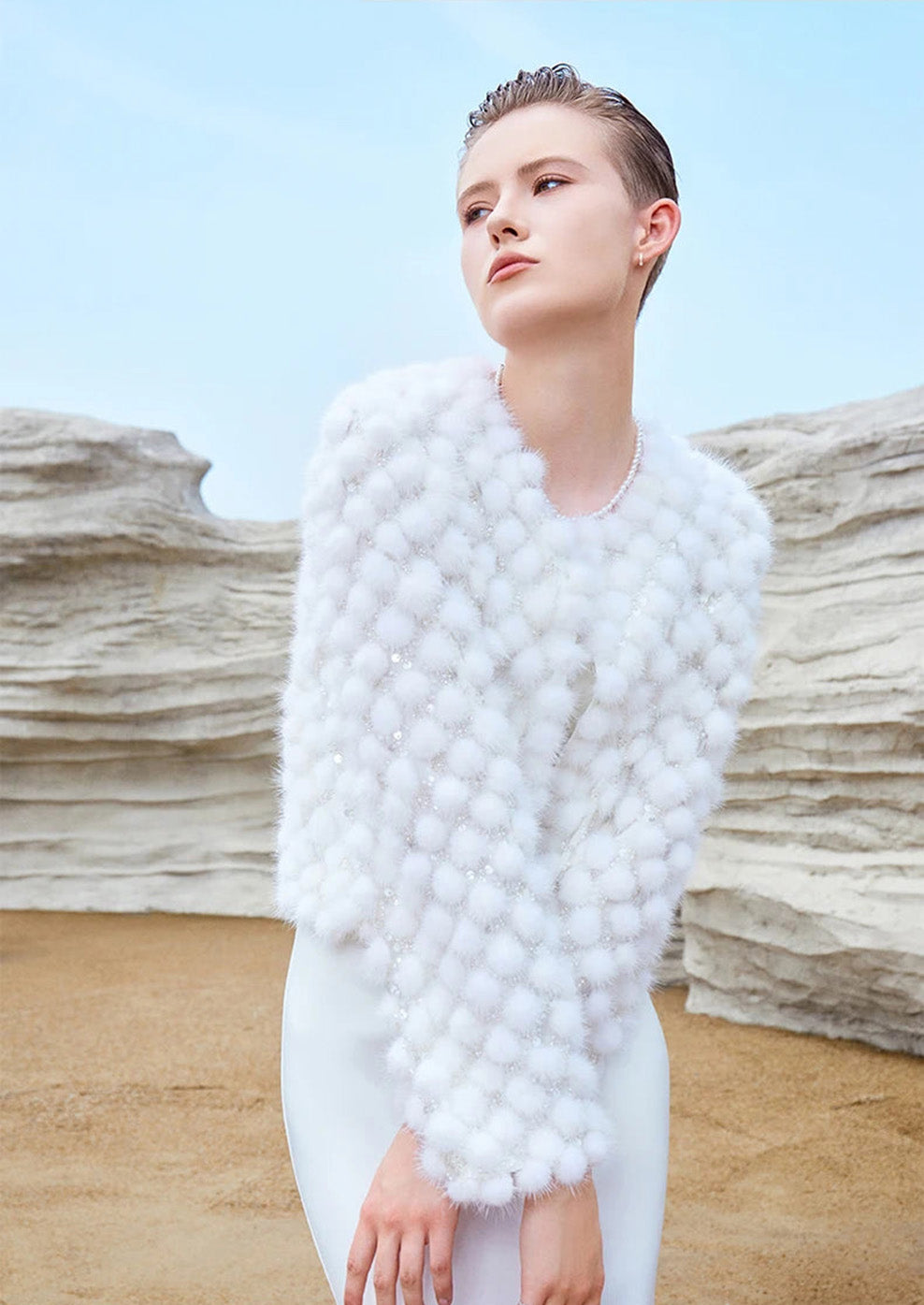 Model standing with arms crossed in the Women’s Inlaid Mink Mosaic Coat in White Whimsy, displaying overall silhouette and volume — From Borcelleclothes.