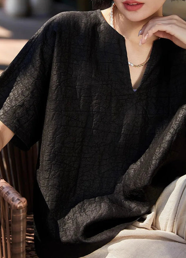 Model wearing the Beyond Control Xiangyunsha Mulberry silk top while seated in a wicker chair, showcasing its relaxed drape — From Borcelleclothes.