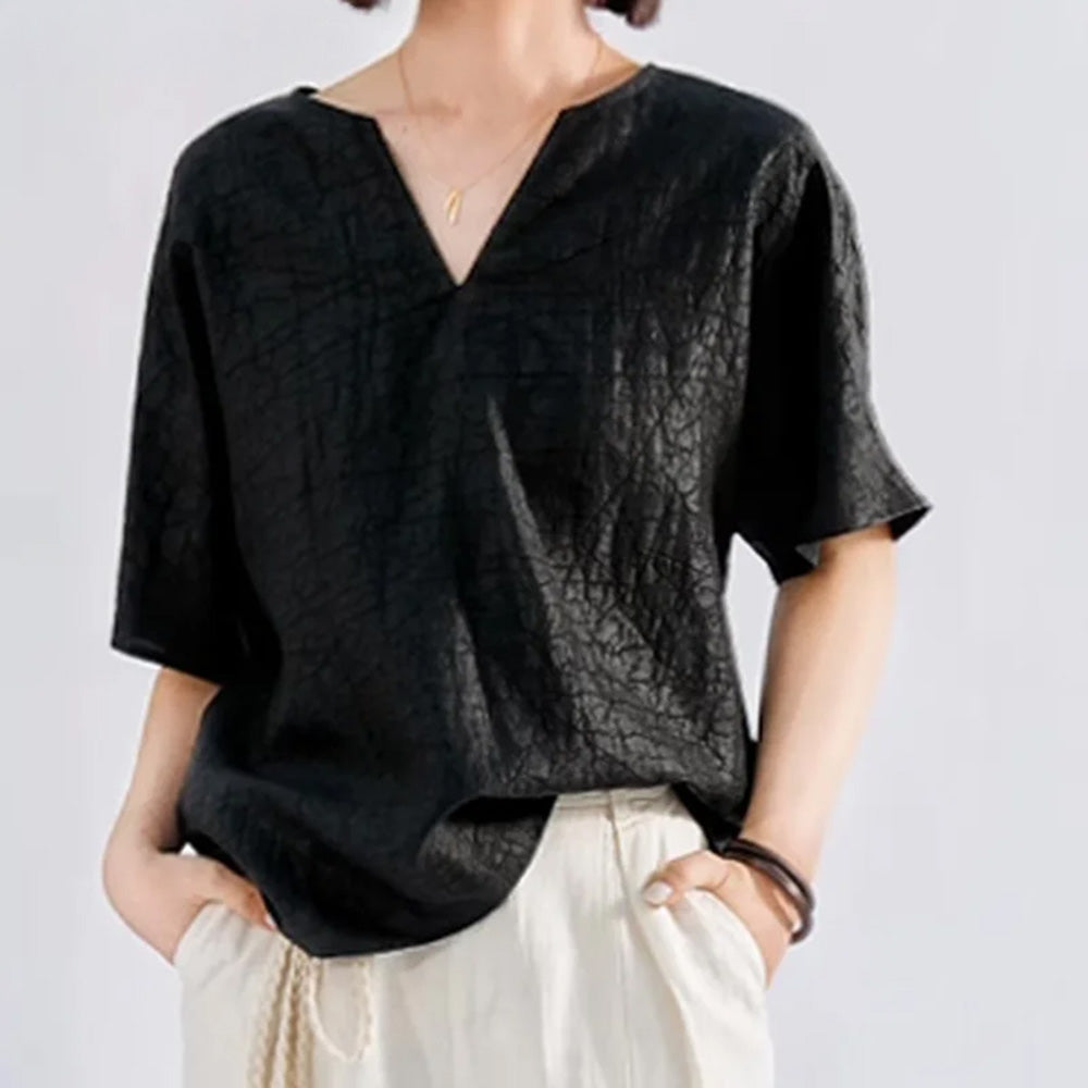 Asymmetrical styling detail showing the Beyond Control silk top with the left hem tucked into high-waisted trousers — From Borcelleclothes.