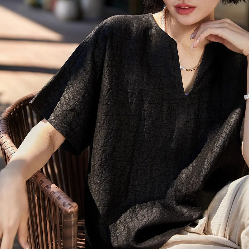 Women's Xiangyunsha Mulberry Silk Top in Beyond Control with an artisanal crackled texture. Features a notch neckline, 1/2 kimono sleeves, and a loose silhouette in deep matte graphite. — From Borcelleclthes.