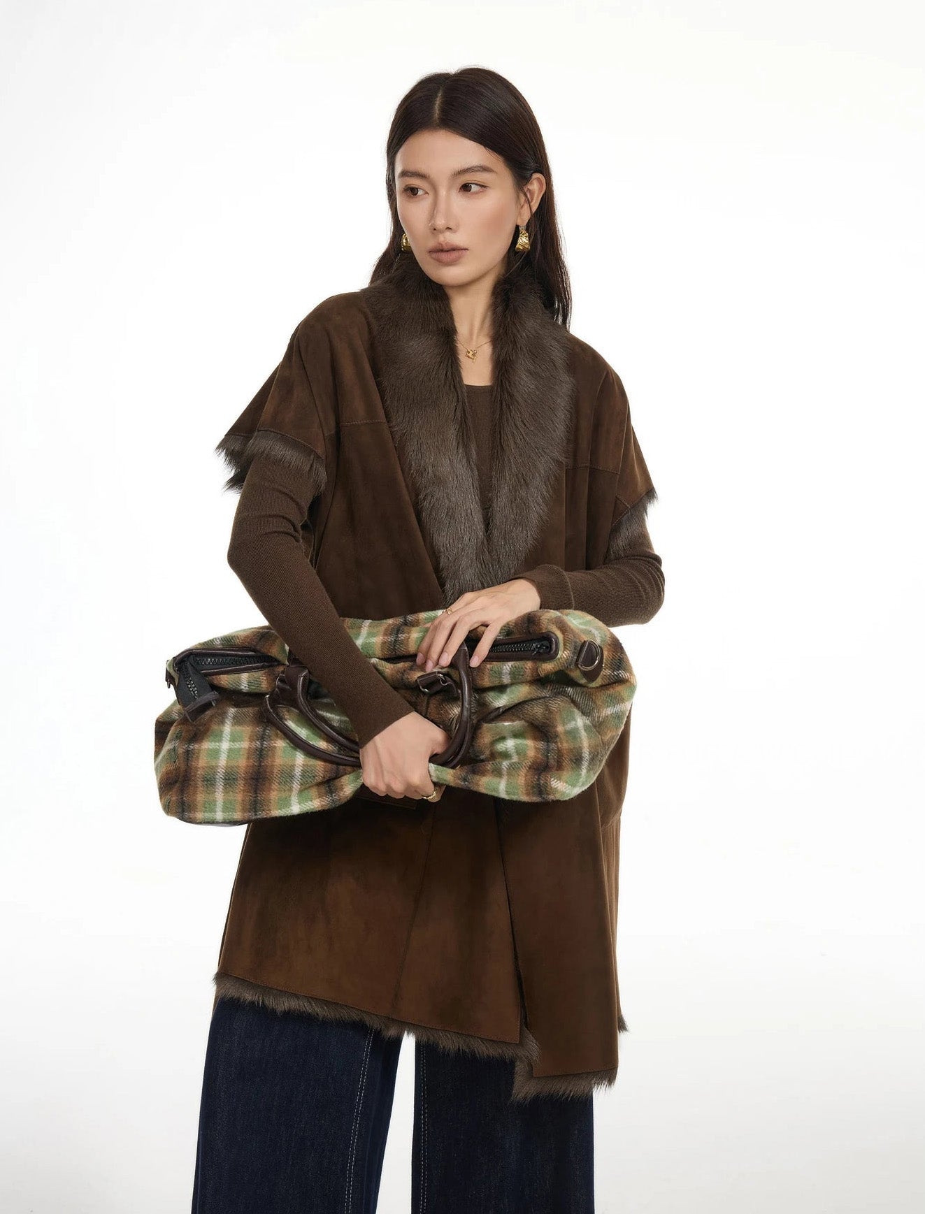 Model holding a handbag with both hands, wearing goatskin jacket in Coffeehouse Chocolate — From Borcelleclothes.