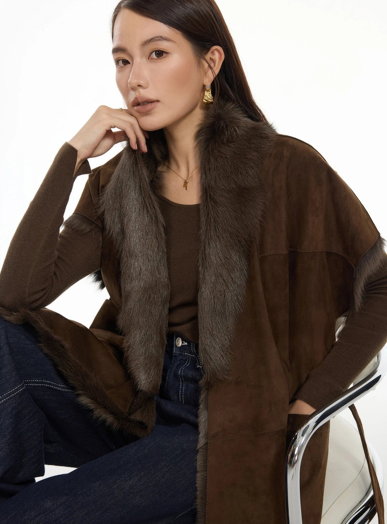 Model seated on a chair wearing Coffeehouse Chocolate goatskin jacket with wrap belt and shawl collar — From Borcelleclothes.