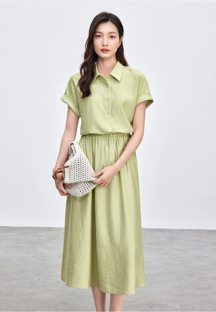 A woman holding a bag in both hands, showcasing the Ginkgo Spell shirt’s kimono sleeves — From Borcelleclothes.