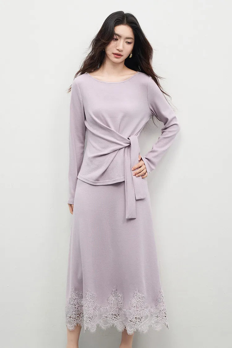 A woman looking down with a hand on her hip, showcasing the natural flow and silhouette of the knit ensemble. — From Borcelleclothes.