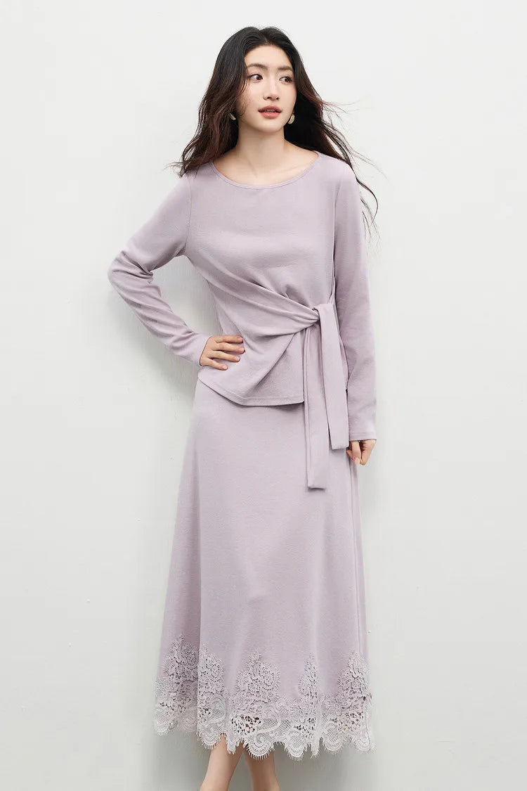 Close-up of a woman with her hand on her hip, showcasing the sculpted drape of the knit top in Almost There color. — From Borcelleclothes.
