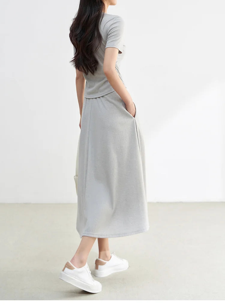 Side profile of a woman wearing the Incognito light grey flared ribbed knit set — From Borcelleclothes.