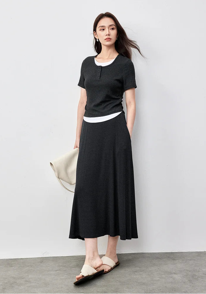 Elegant woman wearing a Mojo dark grey ribbed knit set, holding a white handbag — From Borcelleclothes.