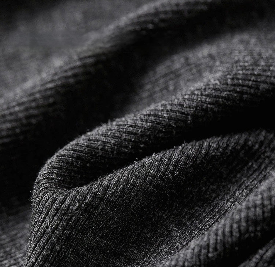 Macro shot of the Mojo dark grey 1x1 ribbed knit texture in a wave-folded pattern — From Borcelleclothes.