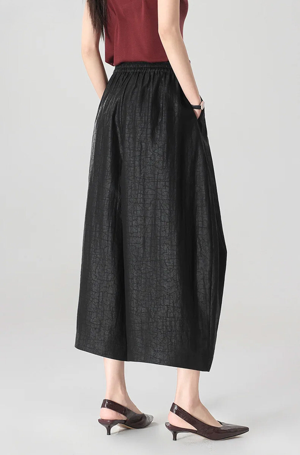 Back view of a woman wearing black Xiangyunsha Mulberry silk lantern pants in Tortoise Ticket — From Borcelleclothes.