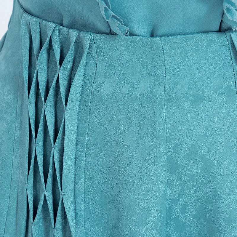 Close-up view of the front waist panel on a woman, focusing on the hand-tacked lattice pleating and seamless waist finish in Lapis Waters Mulberry silk jacquard. — From Borcelleclothes.