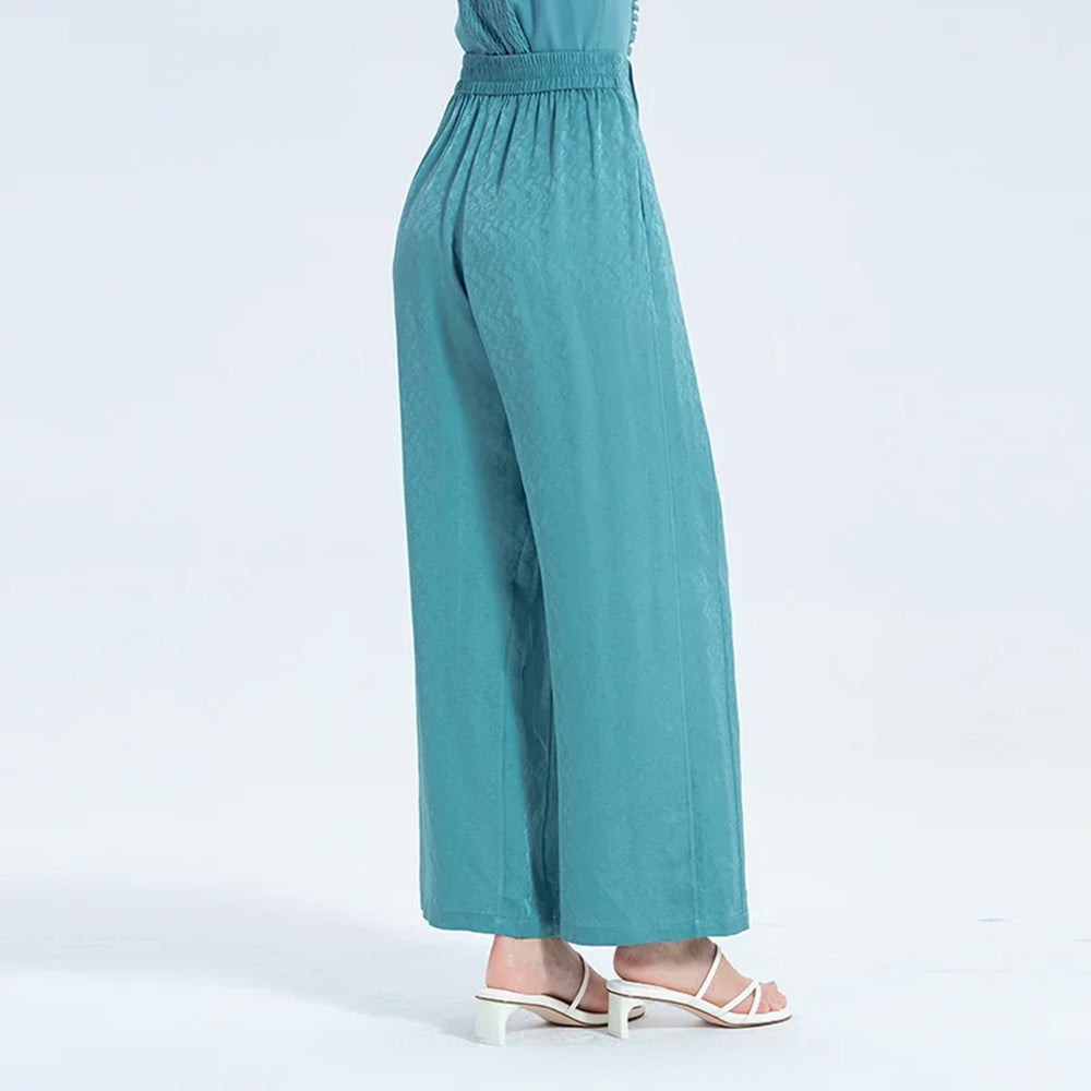 Back view of a woman in Lapis Waters Mulberry silk trousers, highlighting the effortless fit and refined drape around the waist and hips. — From Borcelleclothes.