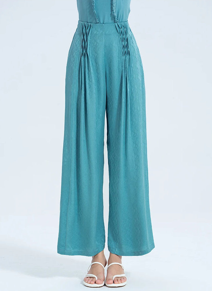 Woman in a high-rise silk ensemble featuring wide-leg Mulberry silk trousers with a sculpted lattice waist in deep Lapis Waters blue. — From Borcelleclothes.