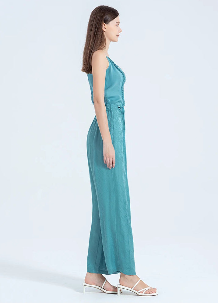 Full-length side profile of a woman in wide-leg silk trousers, showing the seamless waistline and graceful floor-length movement. — From Borcelleclothes.