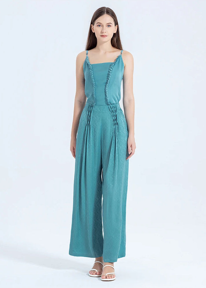 Full-height view of a woman standing in floor-length Mulberry silk jacquard trousers, demonstrating their elegant drape and architectural pleating. — From Borcelleclothes.