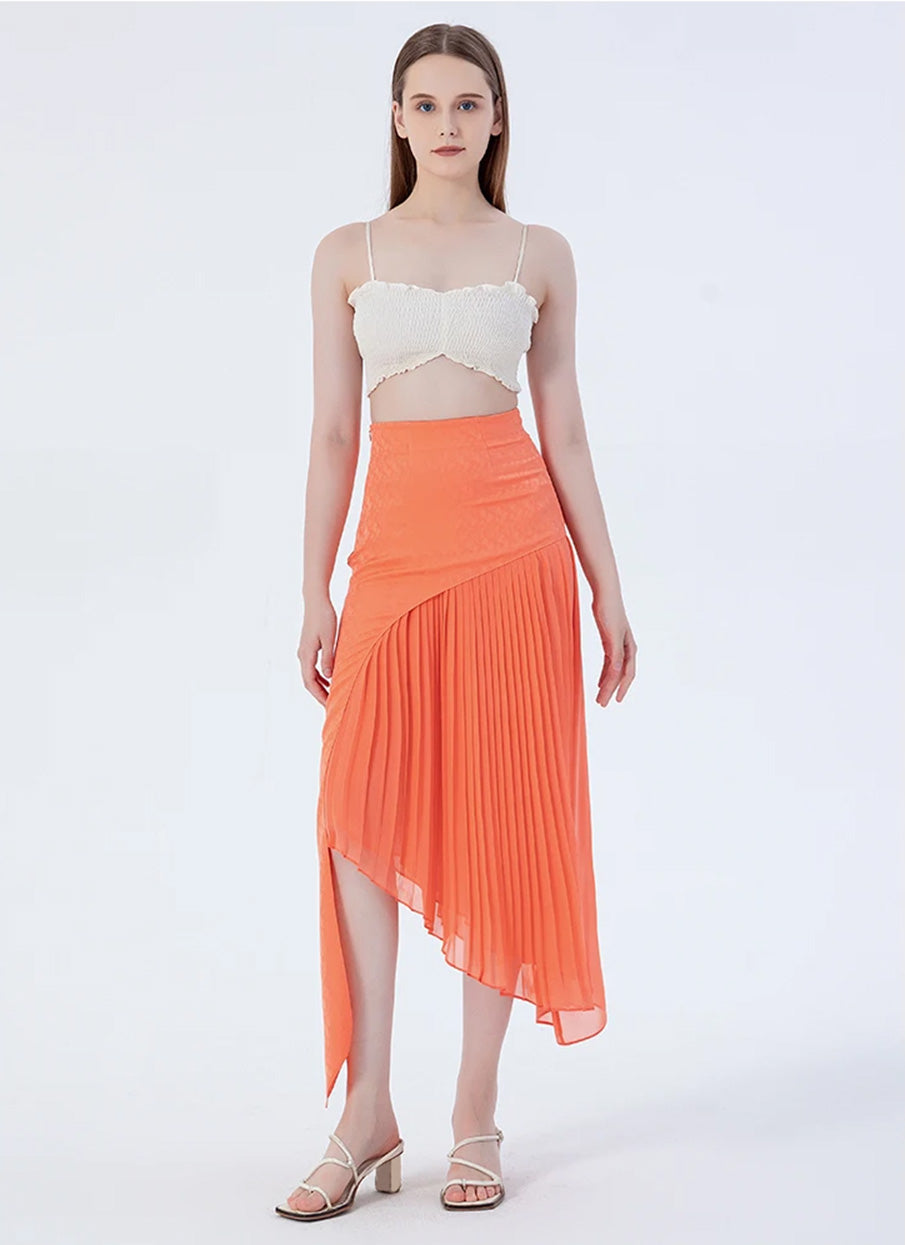 Model posing with a bent leg, showcasing the fluid drape of a women's layered asymmetrical Mulberry silk skirt in Veiltail Gold — From Borcelleclothes.