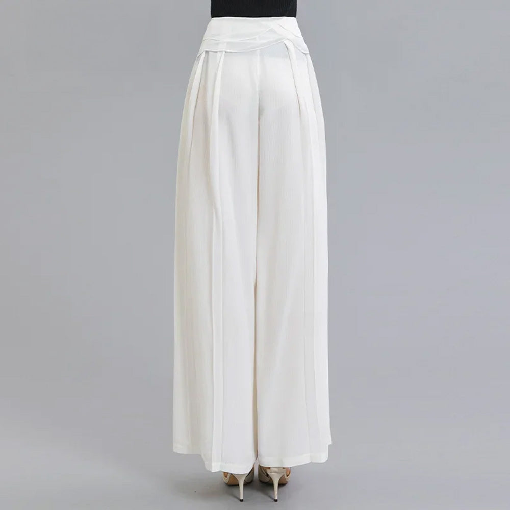 Back view of a woman wearing No Reward wide-leg Mulberry silk trousers with layered waist overlays — From Borcelleclothes.