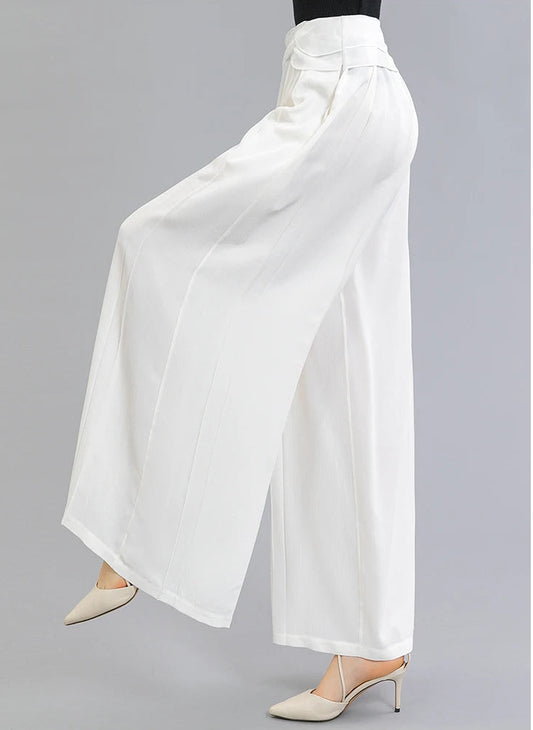 A woman wearing wide-leg Mulberry silk trousers in No Reward with layered waist overlays, posing with one leg raised — From Borcelleclothes.