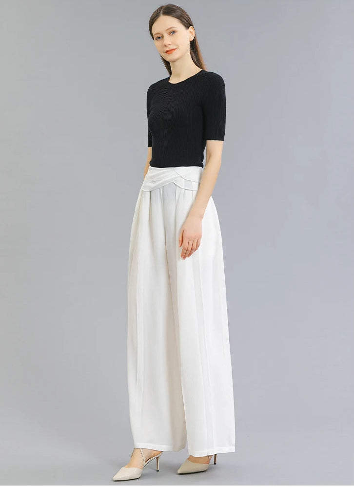 Full-length side profile of a woman wearing No Reward Mulberry silk trousers with draped Georgette waist overlays — From Borcelleclothes.