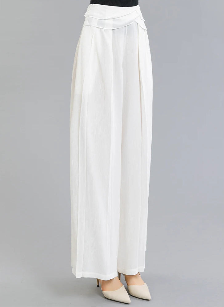 A woman posed turned slightly to the side in Mulberry silk wide-leg trousers with layered waist overlays — From Borcelleclothes.