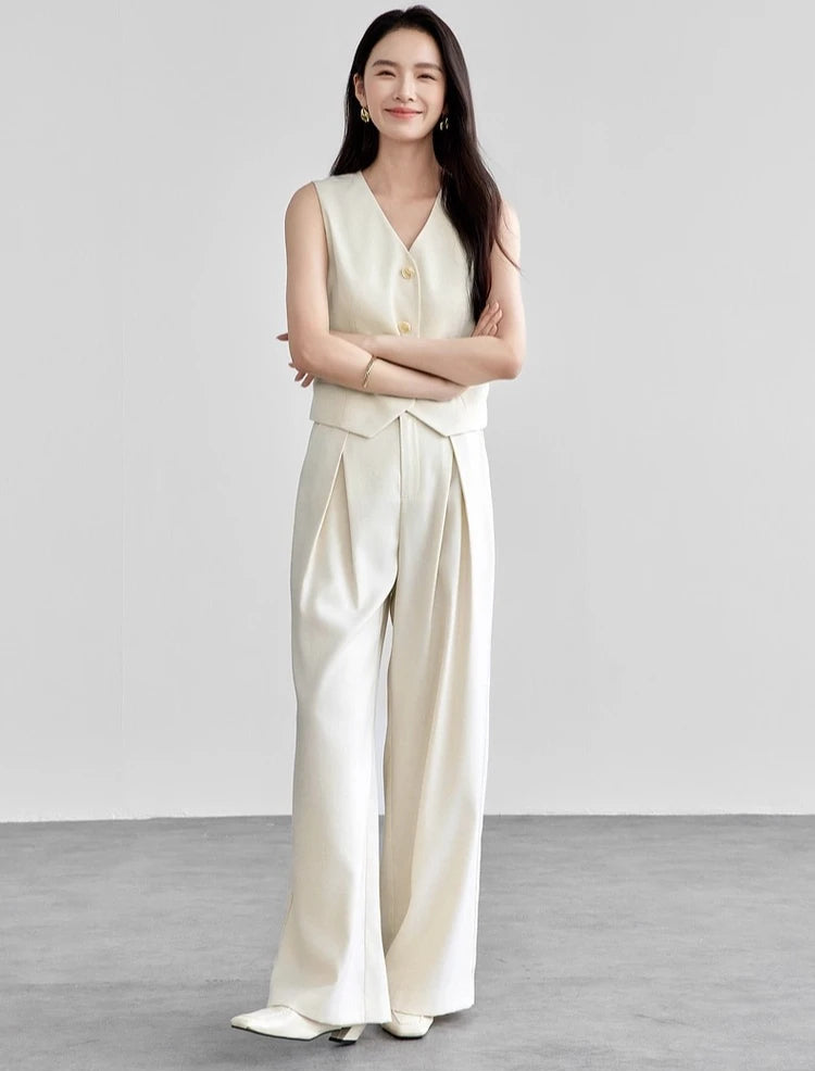 Woman standing with crossed arms wearing a tailored linen blend two-piece set. From Borcelleclothes.