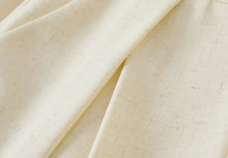 Close-up of the upper section of cream trousers featuring deep inverted pleats. From Borcelleclothes.
