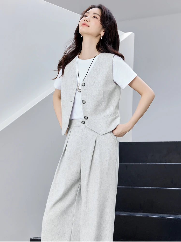 Woman standing on the stairs and looking up, wearing a gray two-piece set. From Borcelleclothes.
