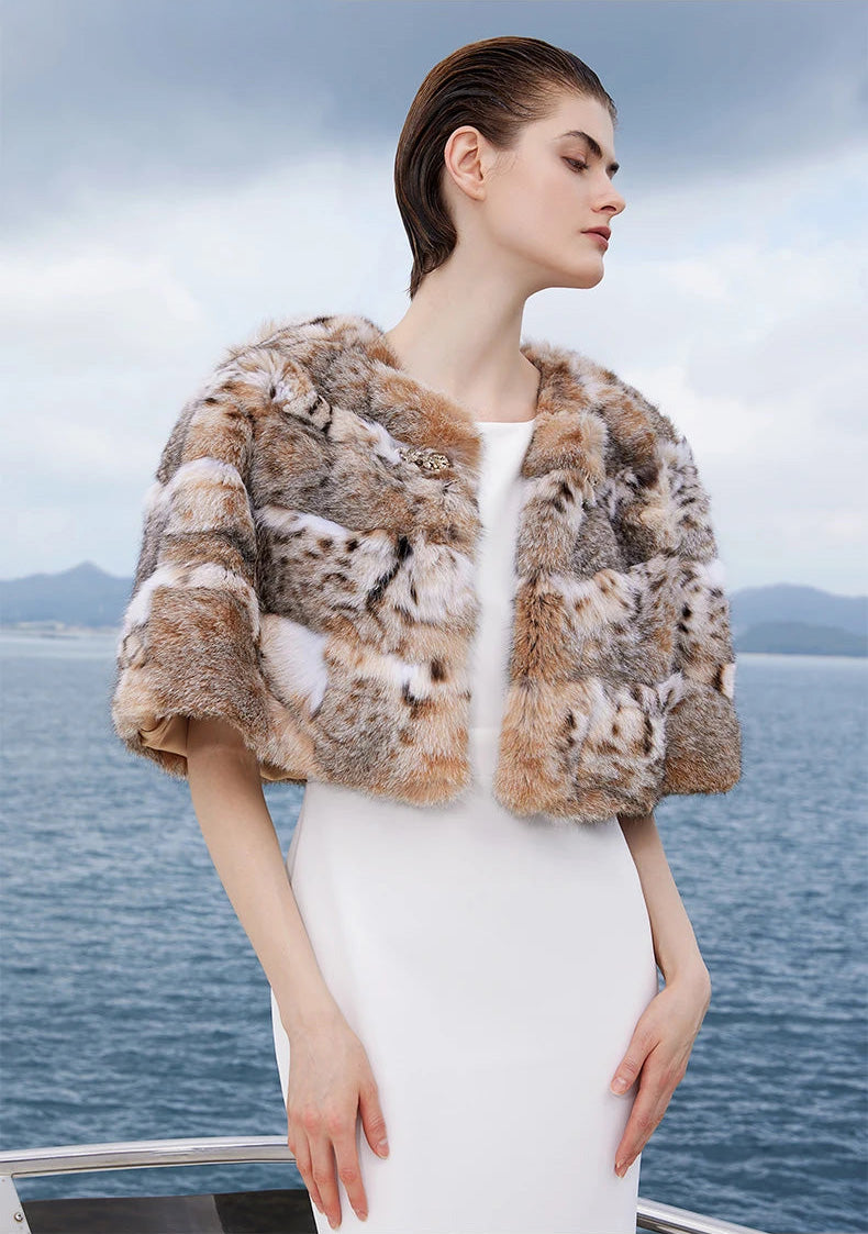 Model resting hands on hips in the lynx cape in Shades of Forest, emphasizing shape and pattern distribution — From Borcelleclothes.