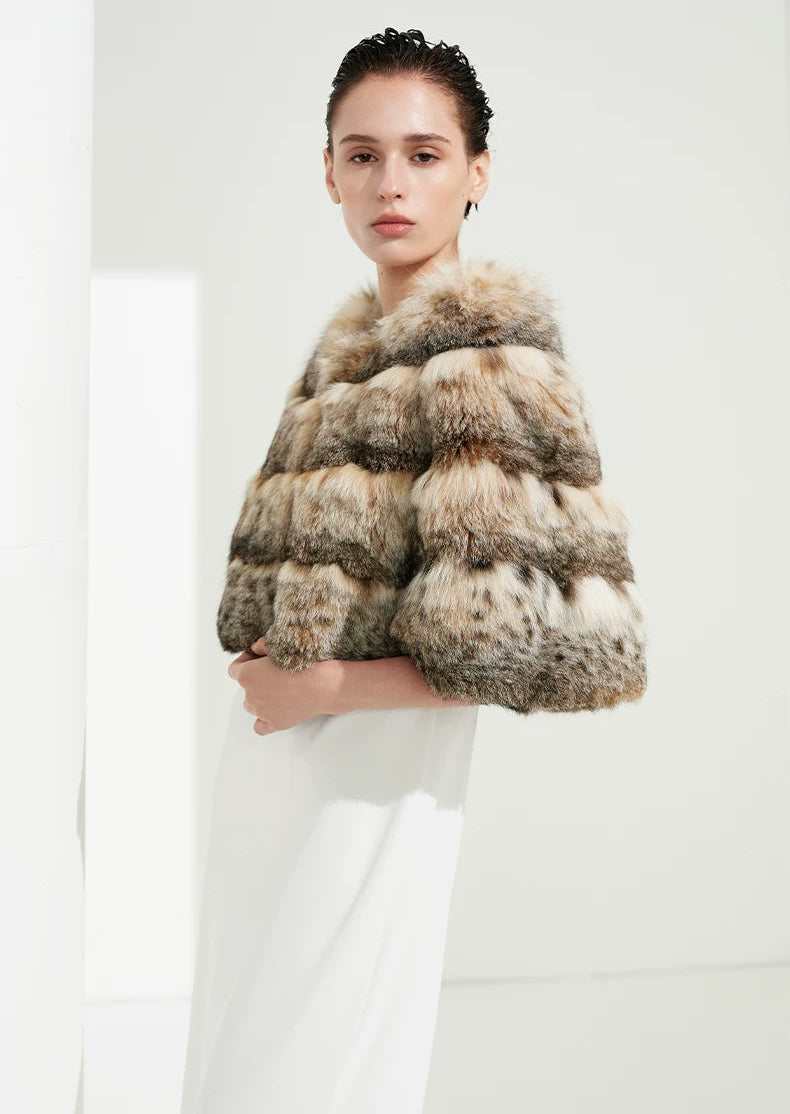Profile view of a woman showcasing the sculpted collar line and relaxed drape of the cropped lynx cape — From Borcelleclothes.