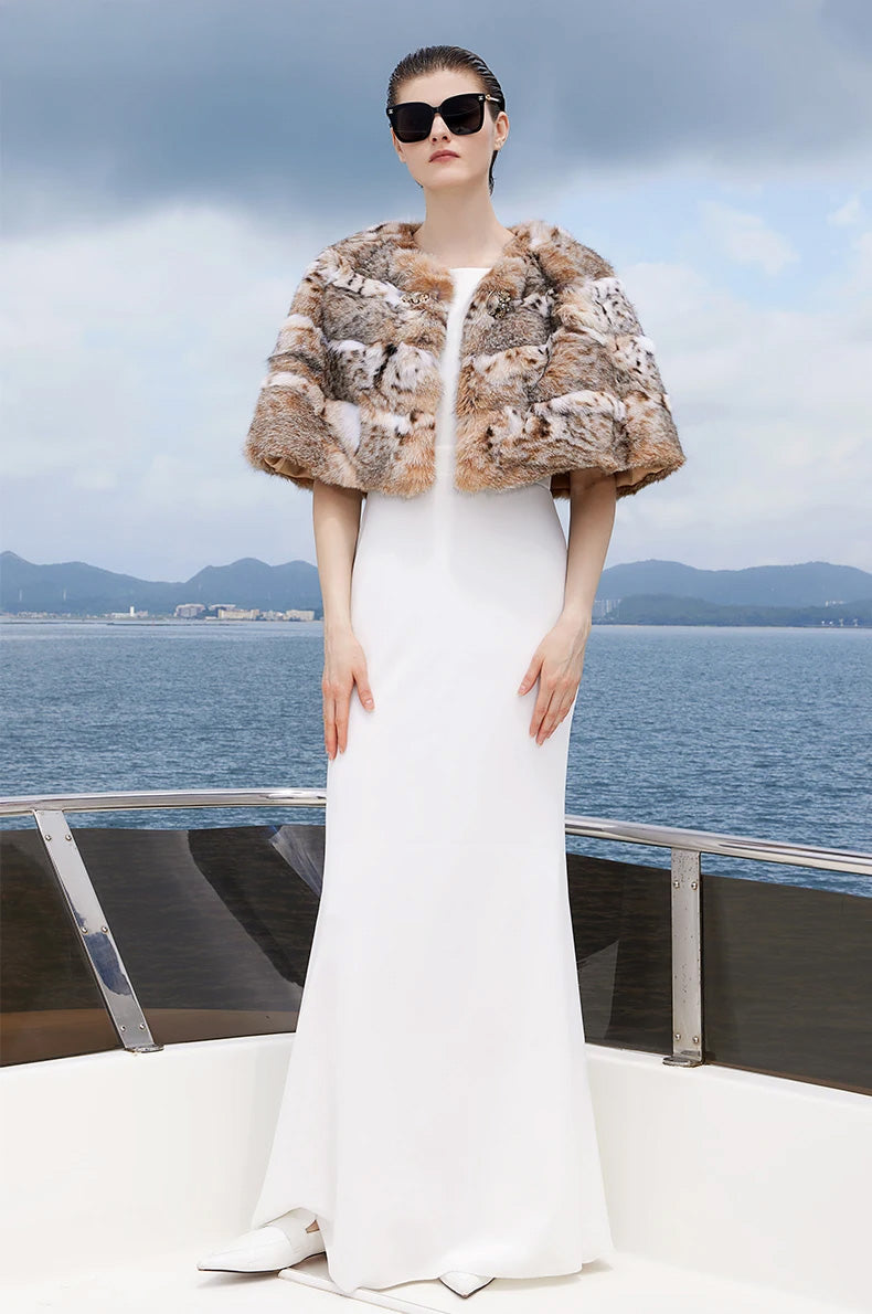 Model standing straight in the lynx fur cape in Shades of Forest, showing the natural pattern and rounded cut — From Borcelleclothes.